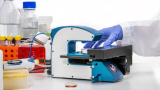 The HoloMonitor M4 cell culture microscope on a lab bench next to cell culture accessories