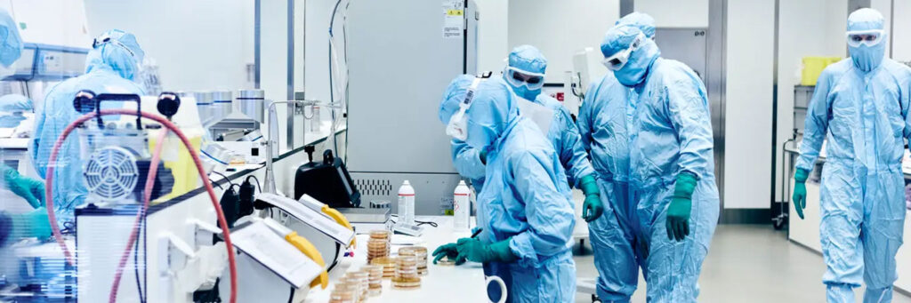 Scientists in protective gear working in a cell laboratory.